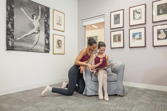 Jeunes danseuses qui regardent un livre dans la bibliothèque de la danse Vincent-Warren